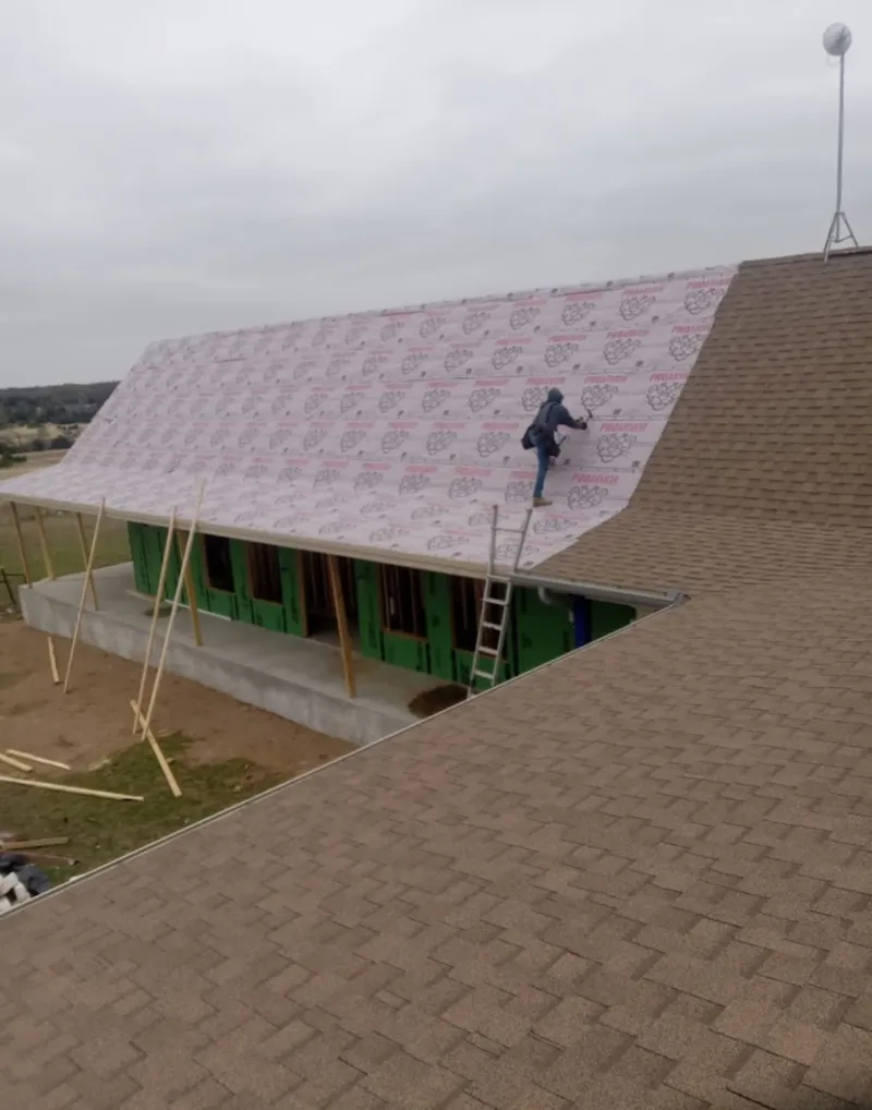 Worker preparing underlayment for a metal roof installation in Camp Hill